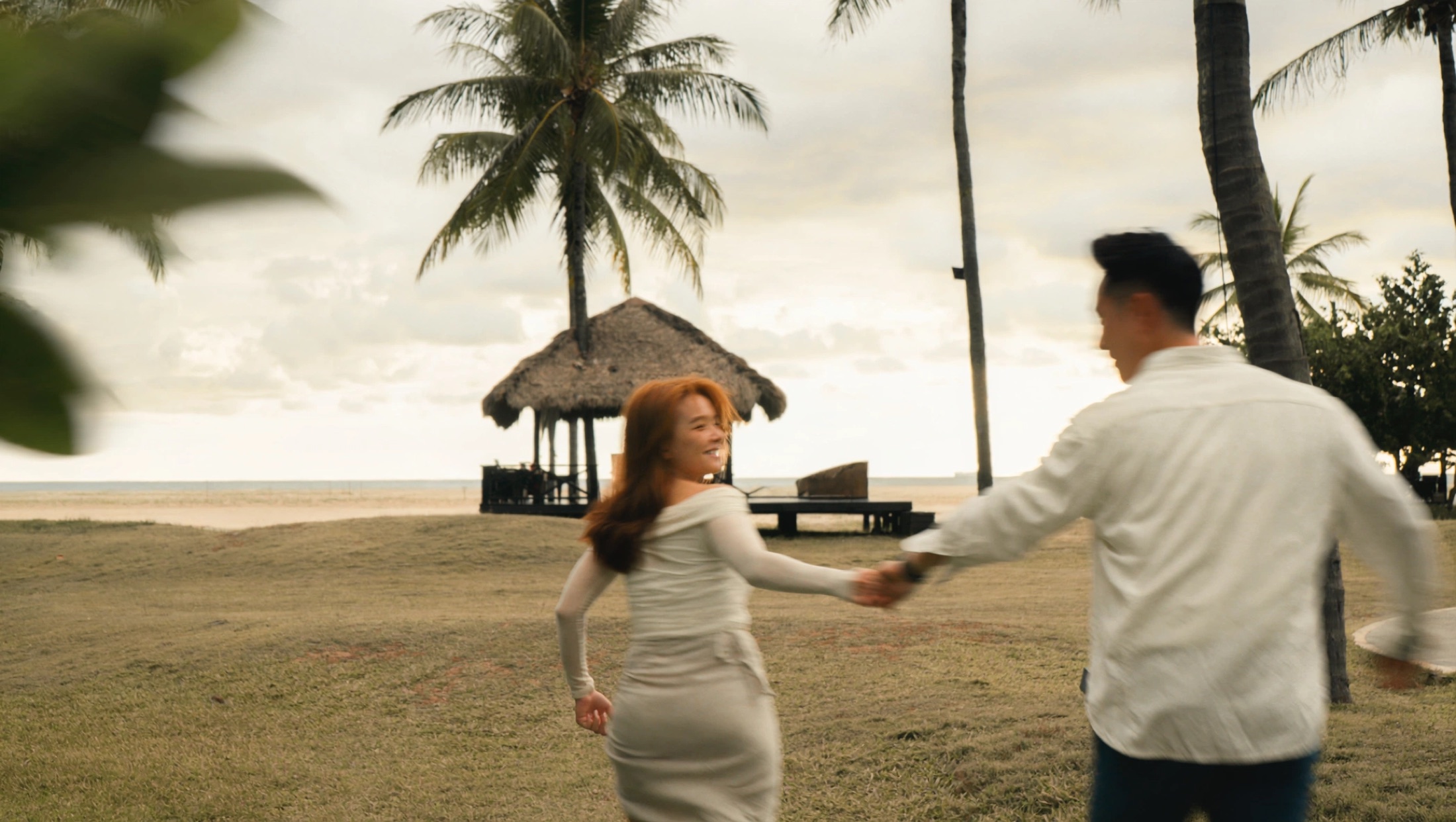 Ian and Phylicia running by the beach at golden hour